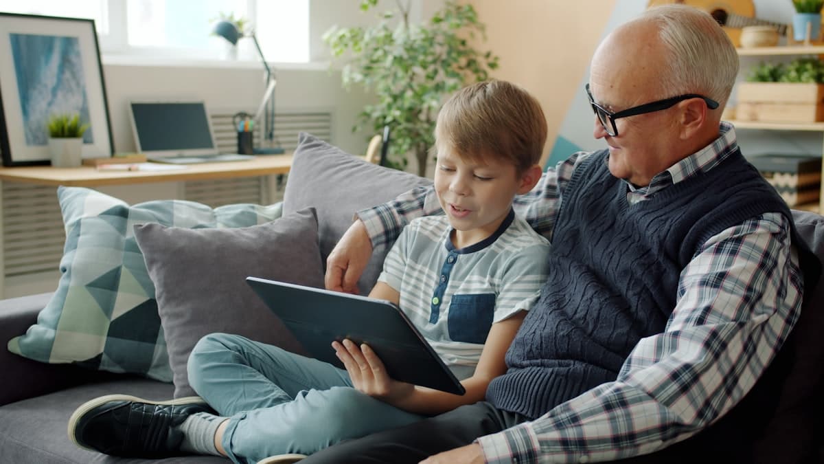 A grandfather and grandson looking at a tablet together